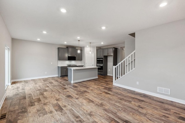kitchen featuring wood finished floors, visible vents, double oven, and gray cabinets