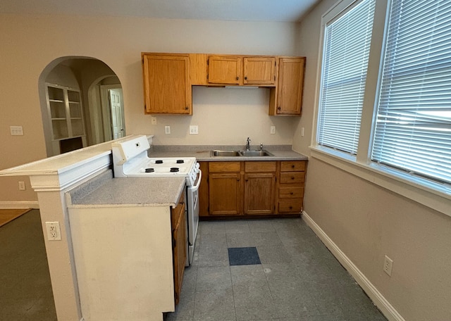 529 Blair Ave, Saint Paul, MN 55103 - kitchen featuring white stove, light countertops, a peninsula, and brown cabinetry