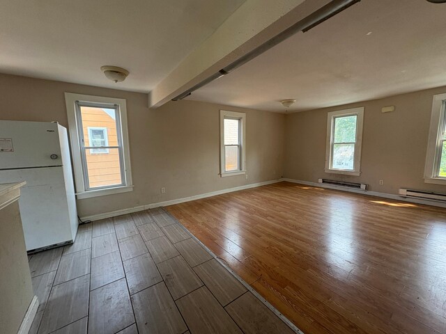 529 Blair Ave, Saint Paul, MN 55103 - empty room featuring wood finished floors, a baseboard heating unit, healthy amount of natural light, and beam ceiling
