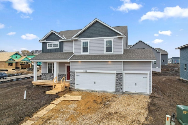 craftsman inspired home featuring stone siding, driveway, covered porch, and a garage
