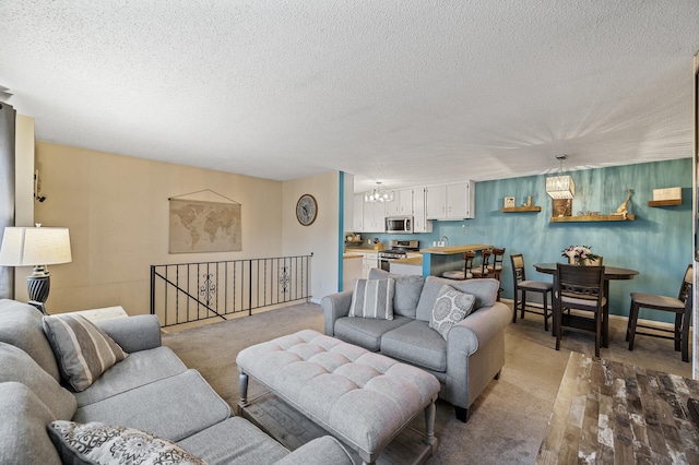 living room featuring a textured ceiling, an inviting chandelier, and carpet
