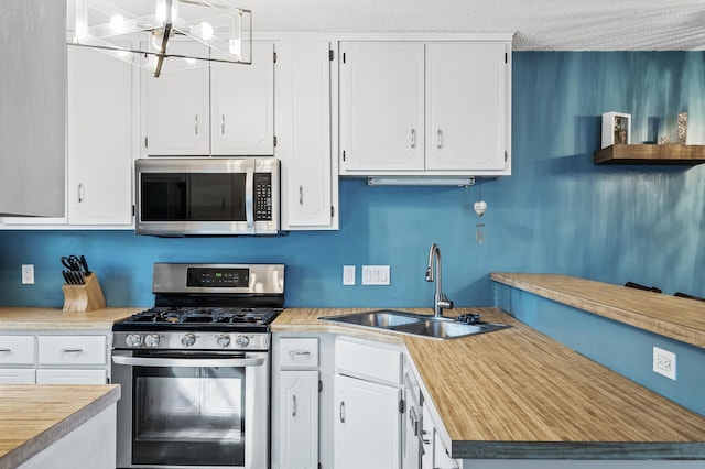 kitchen with a sink, white cabinetry, appliances with stainless steel finishes, and light countertops