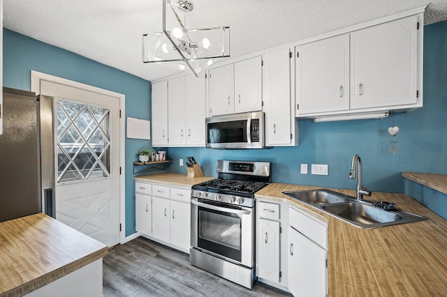 kitchen featuring a sink, dark wood-style flooring, appliances with stainless steel finishes, and white cabinets