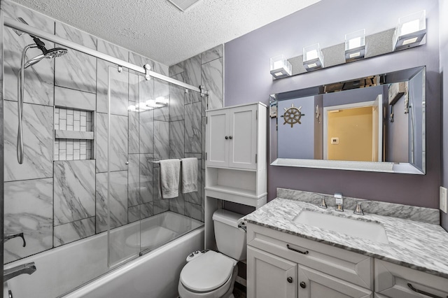 bathroom with vanity, a textured ceiling, enclosed tub / shower combo, and toilet
