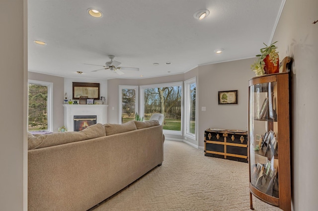 1205 Melvina Rd SW, Alexandria, MN 56308 - living area with ornamental molding, a glass covered fireplace, light carpet, baseboards, and recessed lighting