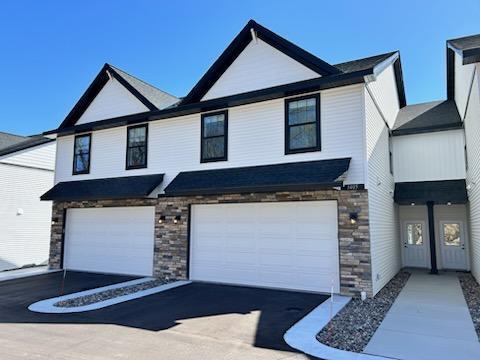 3405 Douglas Dr N, Crystal, MN 55422 - view of front facade with a garage, aphalt driveway, and stone siding