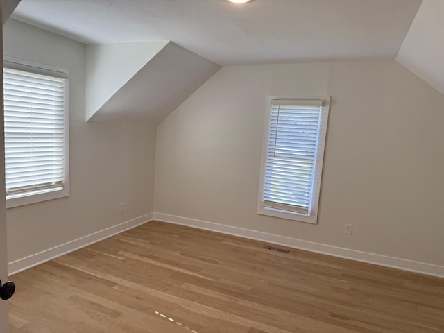 436 Adams St SE, Hutchinson, MN 55350 - bonus room featuring baseboards, vaulted ceiling, light wood finished floors, and visible vents