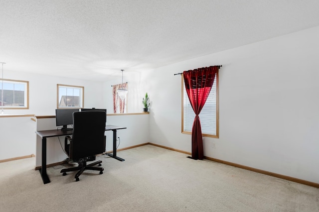 carpeted home office featuring baseboards and a textured ceiling