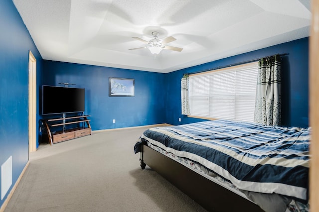 bedroom with visible vents, baseboards, ceiling fan, carpet floors, and a raised ceiling