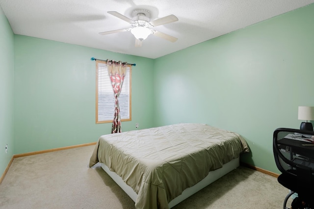bedroom with carpet floors, a textured ceiling, baseboards, and ceiling fan