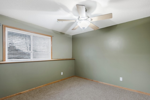 carpeted empty room with baseboards and ceiling fan