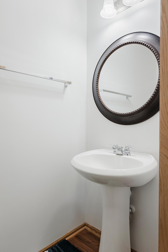 bathroom featuring wood finished floors, baseboards, and a sink