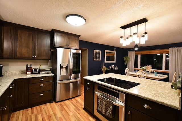 1164 Hawthorn St, Red Wing, MN 55066 - kitchen with appliances with stainless steel finishes, light wood-style floors, dark brown cabinetry, a textured ceiling, and hanging light fixtures