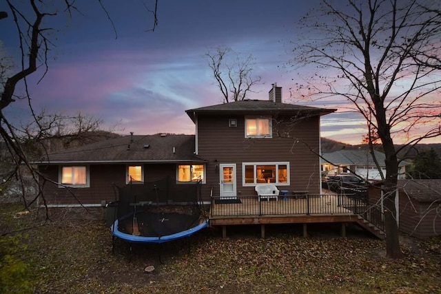 1164 Hawthorn St, Red Wing, MN 55066 - back of house with a trampoline, a chimney, and a deck