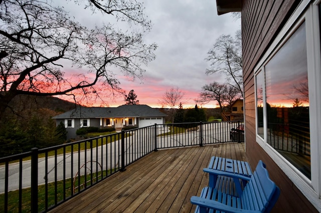 1164 Hawthorn St, Red Wing, MN 55066 - deck at dusk featuring an attached garage and concrete driveway