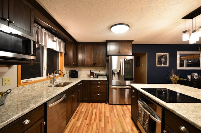1164 Hawthorn St, Red Wing, MN 55066 - kitchen with stainless steel appliances, a sink, light wood-type flooring, dark brown cabinets, and a textured ceiling