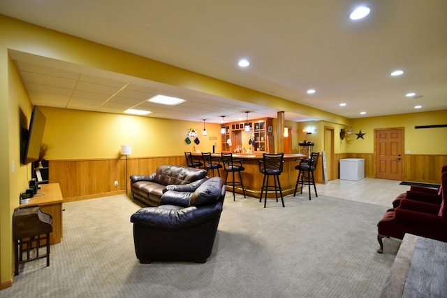 1164 Hawthorn St, Red Wing, MN 55066 - living room with wainscoting, recessed lighting, light colored carpet, wood walls, and bar