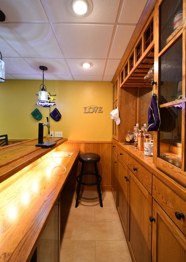 1164 Hawthorn St, Red Wing, MN 55066 - bar featuring a wainscoted wall, a paneled ceiling, light tile patterned flooring, hanging light fixtures, and wood walls