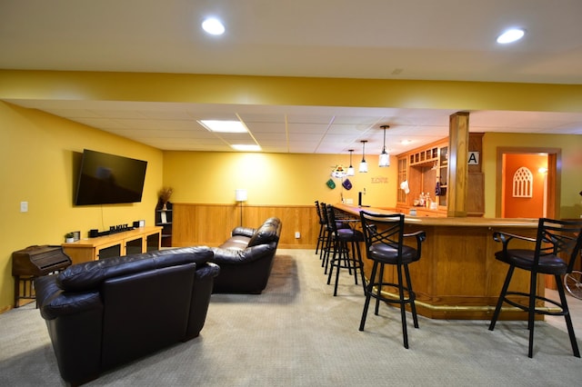 1164 Hawthorn St, Red Wing, MN 55066 - living area featuring carpet flooring, wainscoting, bar area, wood walls, and a drop ceiling