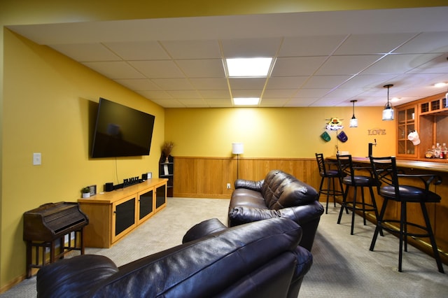 1164 Hawthorn St, Red Wing, MN 55066 - living area featuring carpet floors, bar with sink, a drop ceiling, a wainscoted wall, and wood walls