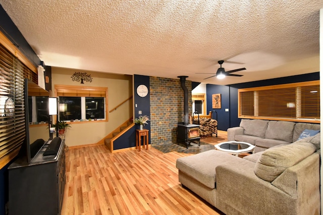 1164 Hawthorn St, Red Wing, MN 55066 - living area featuring a wood stove, ceiling fan, wood finished floors, stairs, and a textured ceiling