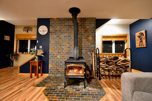 1164 Hawthorn St, Red Wing, MN 55066 - living area with a wood stove, wood finished floors, and baseboards