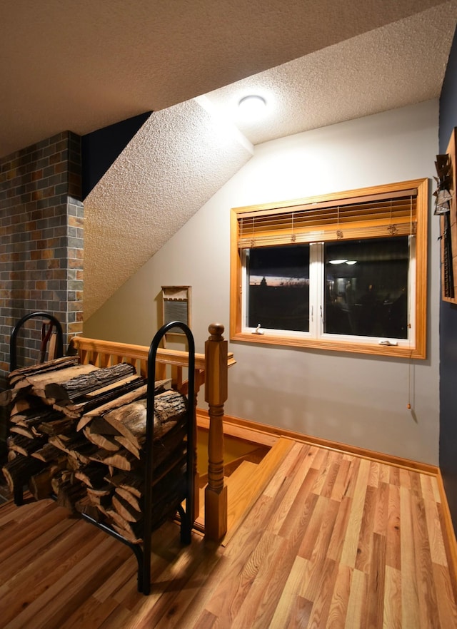 1164 Hawthorn St, Red Wing, MN 55066 - bedroom with a textured ceiling, wood finished floors, baseboards, and lofted ceiling