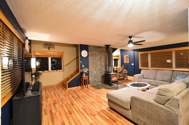 1164 Hawthorn St, Red Wing, MN 55066 - living area with baseboards, wood finished floors, a ceiling fan, a wood stove, and stairs