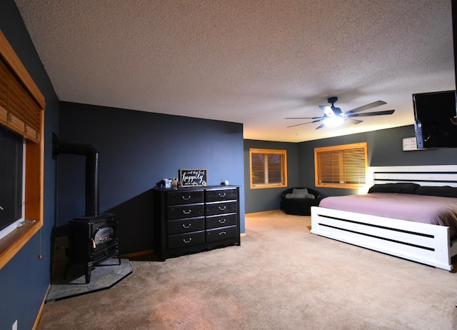 1164 Hawthorn St, Red Wing, MN 55066 - carpeted bedroom with a wood stove, a textured ceiling, and a ceiling fan