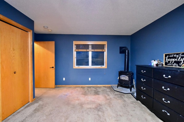 1164 Hawthorn St, Red Wing, MN 55066 - carpeted bedroom featuring a wood stove, a closet, and baseboards