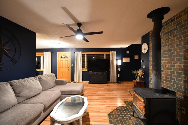 1164 Hawthorn St, Red Wing, MN 55066 - living area with a wood stove, ceiling fan, light wood-style floors, and a textured ceiling