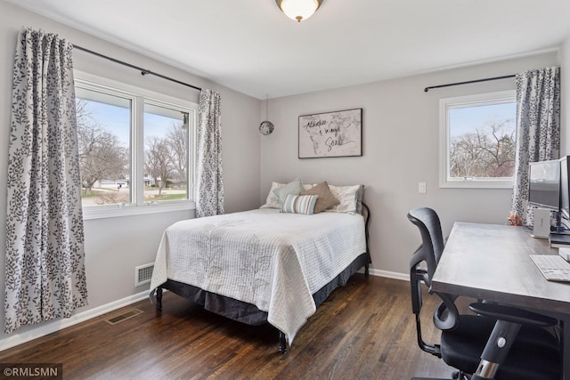 bedroom featuring baseboards, visible vents, and multiple windows