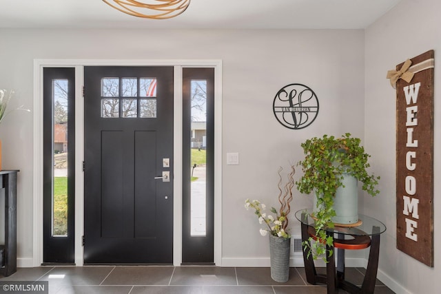 tiled foyer entrance featuring baseboards and a wealth of natural light