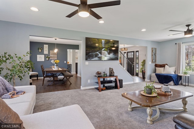 carpeted living area featuring ceiling fan, stairs, recessed lighting, baseboards, and wood finished floors