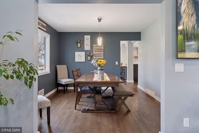 dining area featuring wine cooler, baseboards, hardwood / wood-style flooring, and visible vents