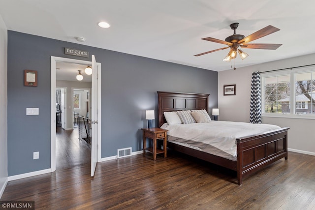 bedroom featuring baseboards, multiple windows, wood finished floors, and visible vents