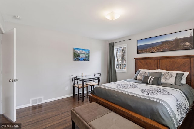 bedroom with baseboards, visible vents, and wood finished floors