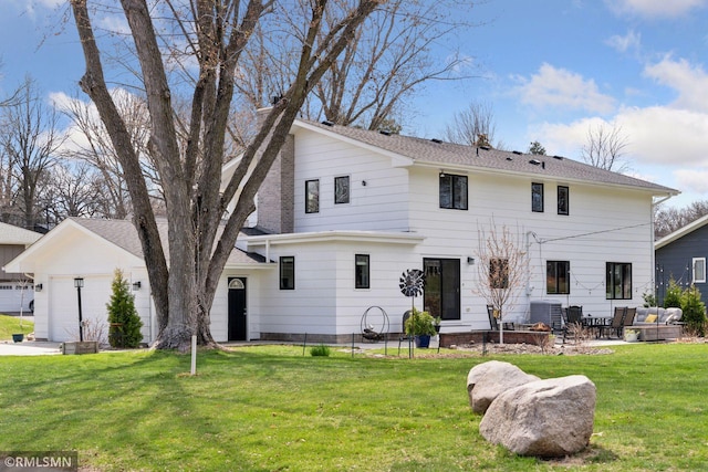 rear view of house with a garage, a patio, an outdoor hangout area, central AC unit, and a lawn