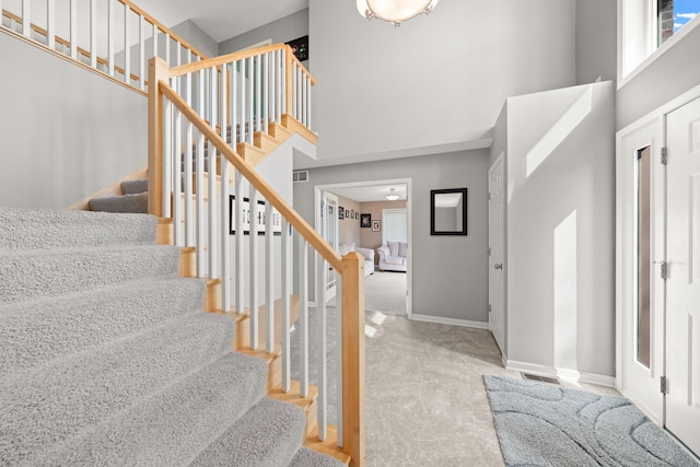 5214 381st Ln, North Branch, MN 55056 - stairway featuring baseboards, visible vents, a high ceiling, and carpet floors