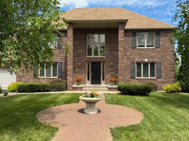 5214 381st Ln, North Branch, MN 55056 - view of front of home featuring a front lawn, roof with shingles, and brick siding