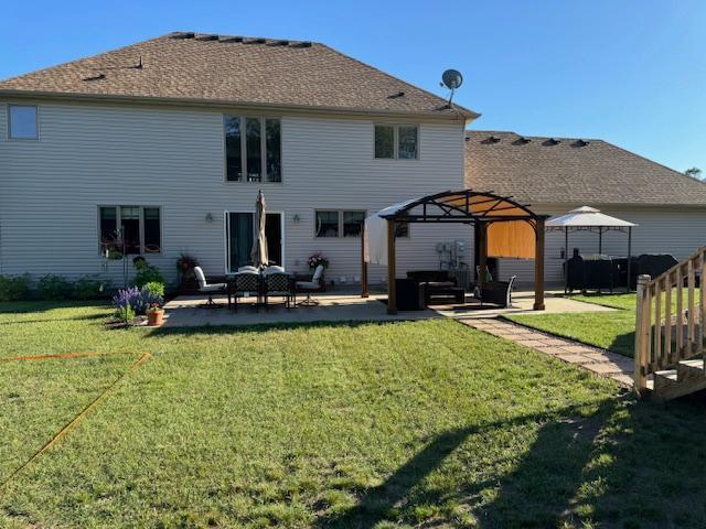 5214 381st Ln, North Branch, MN 55056 - rear view of property with a yard, outdoor lounge area, a gazebo, and a patio area