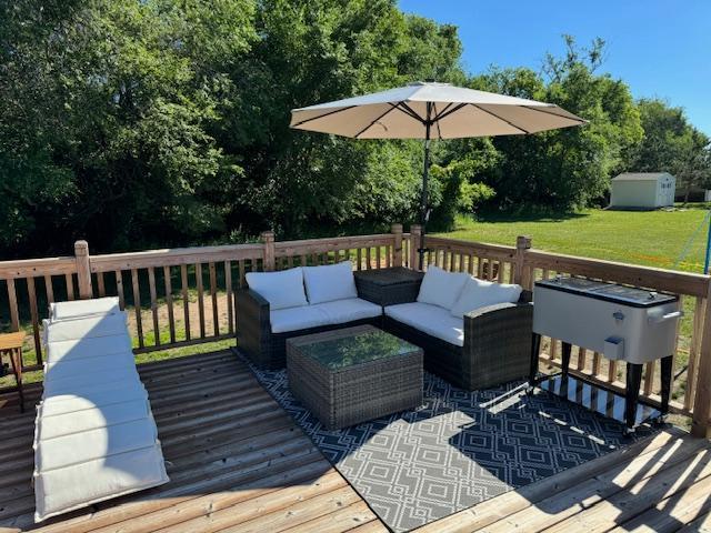 5214 381st Ln, North Branch, MN 55056 - wooden terrace featuring an outdoor structure, a lawn, an outdoor living space, and a storage unit