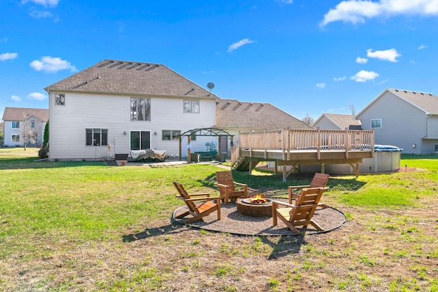 5214 381st Ln, North Branch, MN 55056 - back of house featuring a deck, a fire pit, a patio, and a yard