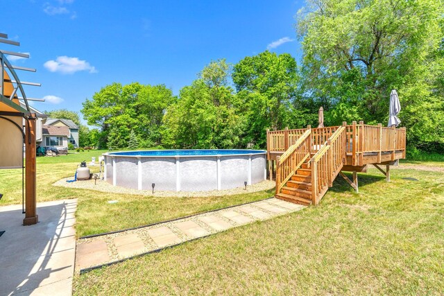 5214 381st Ln, North Branch, MN 55056 - swimming pool with a yard, a wooden deck, and view of wooded area