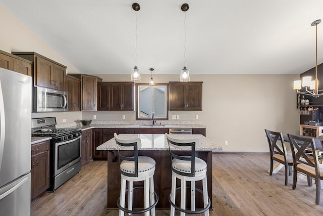 1101 8th Ave SW, Isanti, MN 55040 - kitchen featuring stainless steel appliances, a chandelier, dark brown cabinetry, a center island, and light wood-style floors