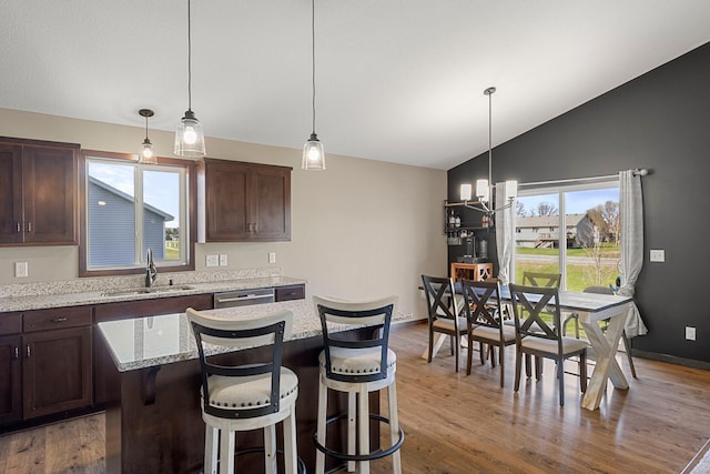1101 8th Ave SW, Isanti, MN 55040 - kitchen with lofted ceiling, dark brown cabinetry, wood finished floors, a sink, and a chandelier