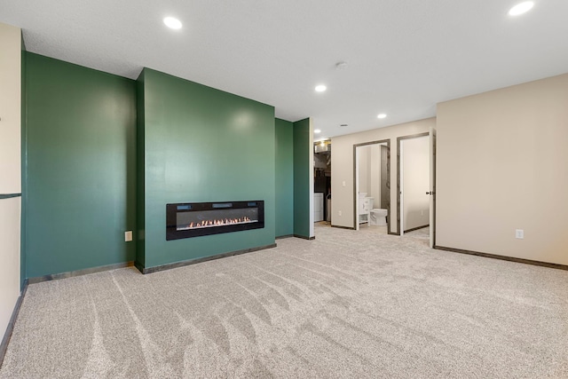1101 8th Ave SW, Isanti, MN 55040 - unfurnished living room with carpet flooring, baseboards, recessed lighting, and a glass covered fireplace