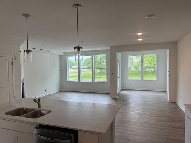 kitchen featuring a sink, open floor plan, healthy amount of natural light, white cabinets, and recessed lighting