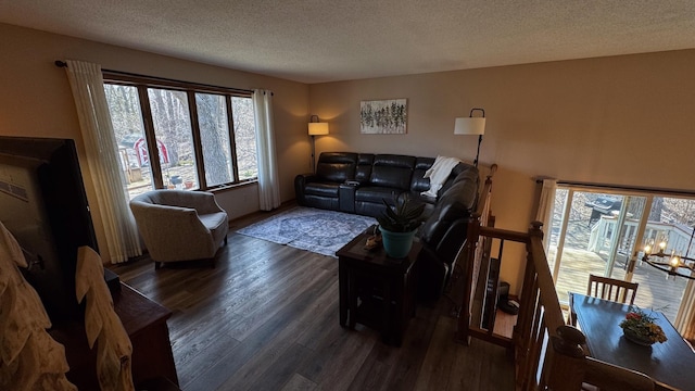living room featuring a textured ceiling, wood finished floors, and a notable chandelier