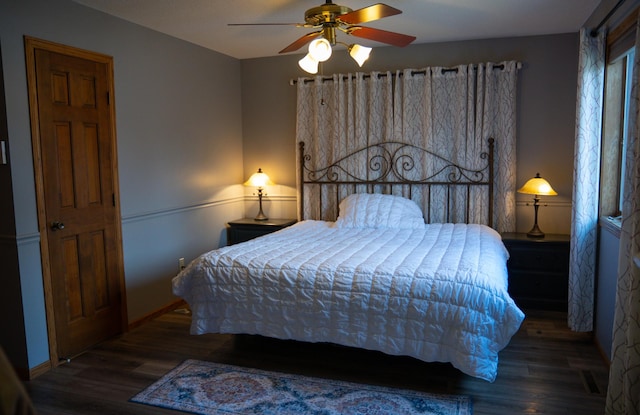 bedroom featuring baseboards, wood finished floors, and a ceiling fan